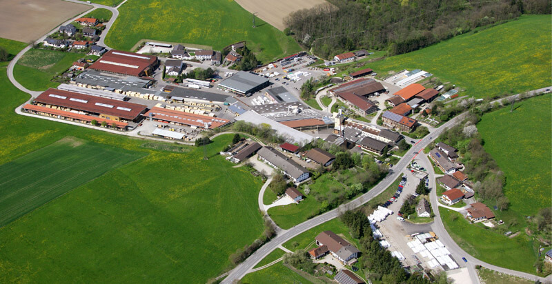 Luftbild eines Holzbauwerks mit Hallen und Holzlager in ländlicher Umgebung