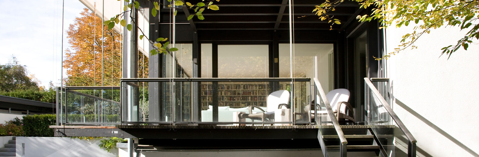 Flachdach-Kubus: Balkon mit Sesseln und Treppe in den Garten