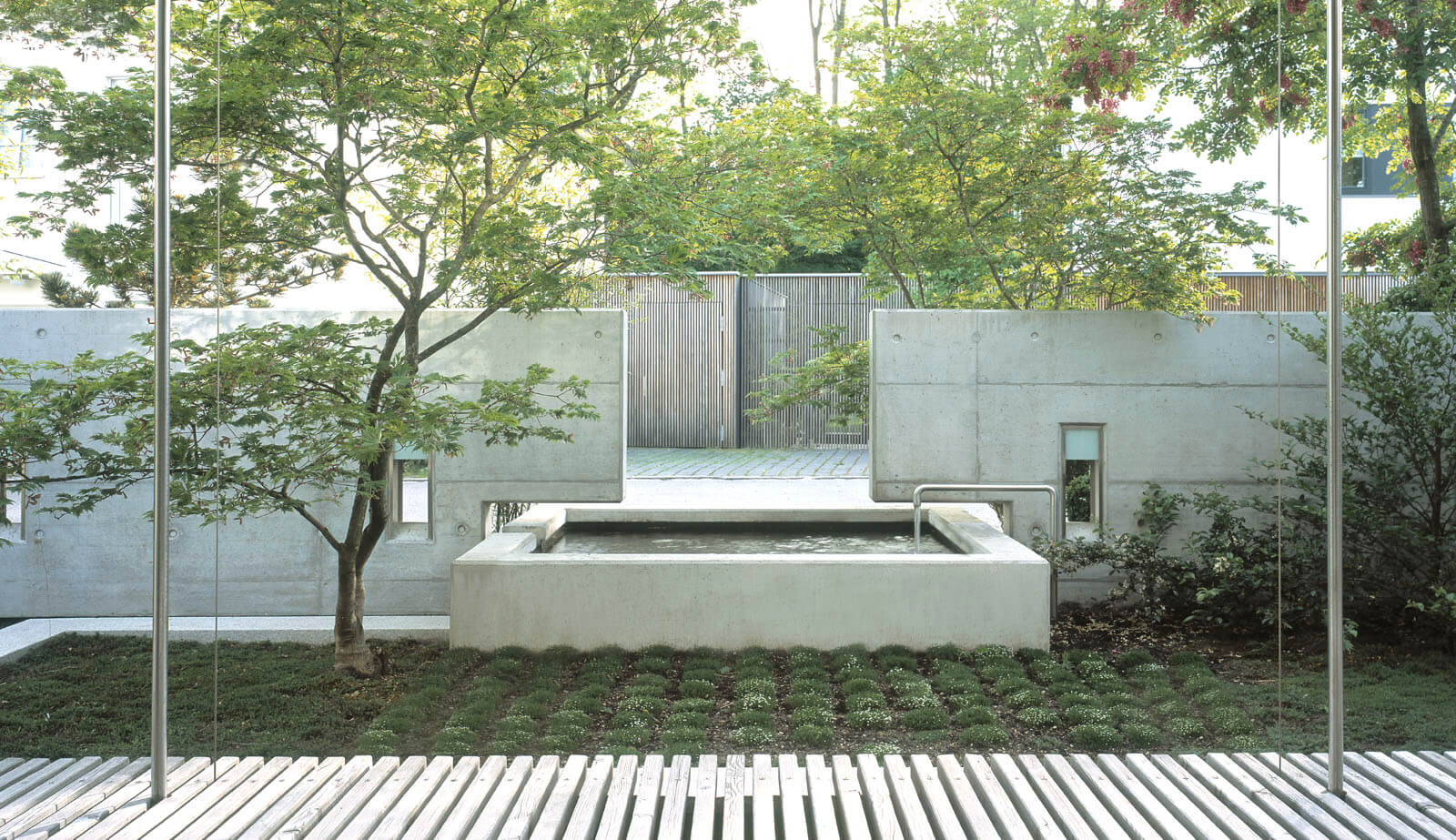 On a small plot: view from the timber deck to concrete fountain and garden walls