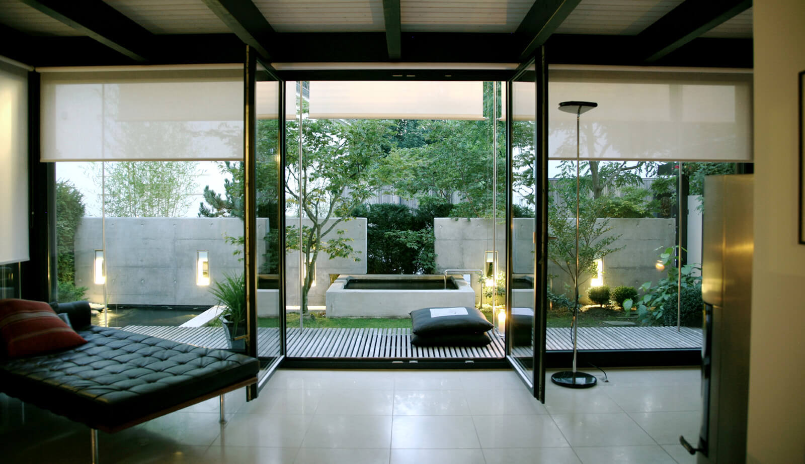 On a small plot: living area with daybed and open glass doors to the garden terrace