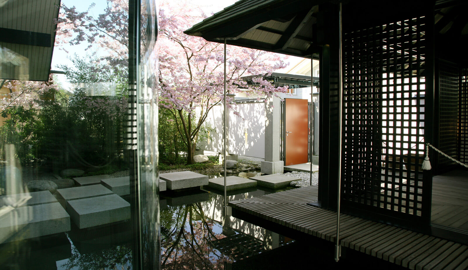 Haus am See: Wasserhof mit Trittsteinen und Holzgitter am Pavillon