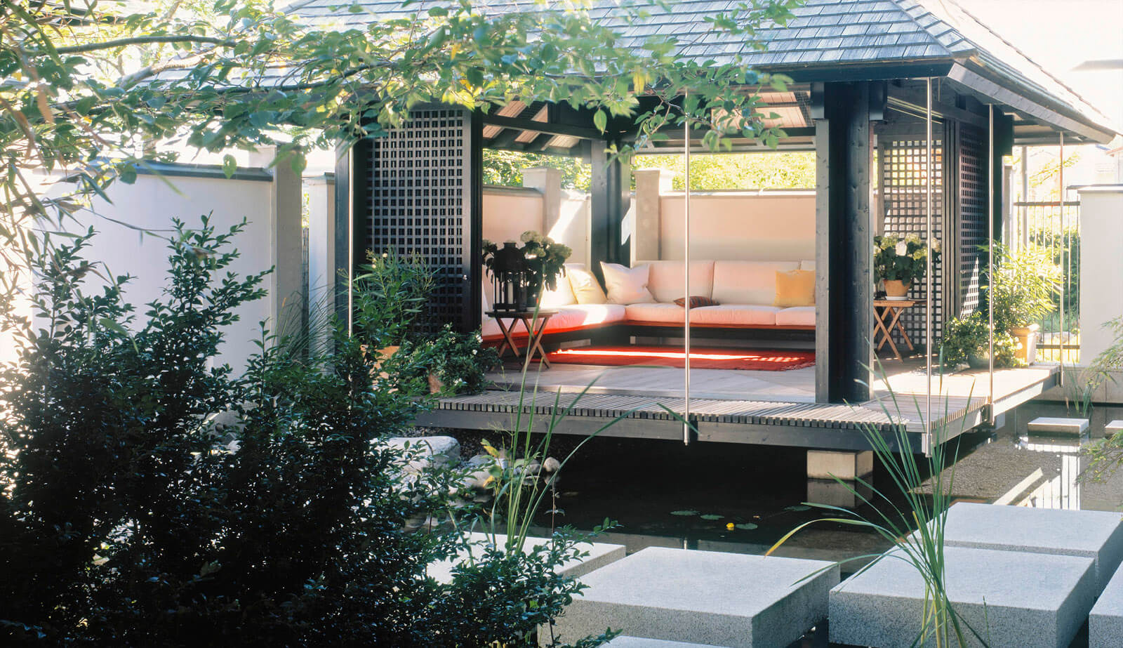 Haus am See: Gartenpavillon mit Sitzecke über dem Wasser