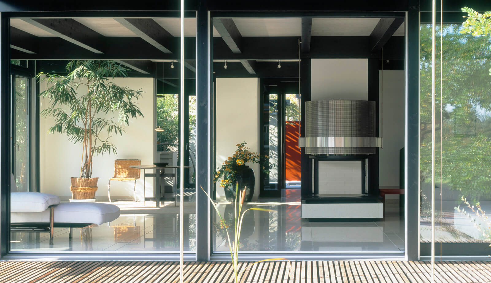 Haus am See: Blick durch die Glasfront in den Wohnraum mit Kamin