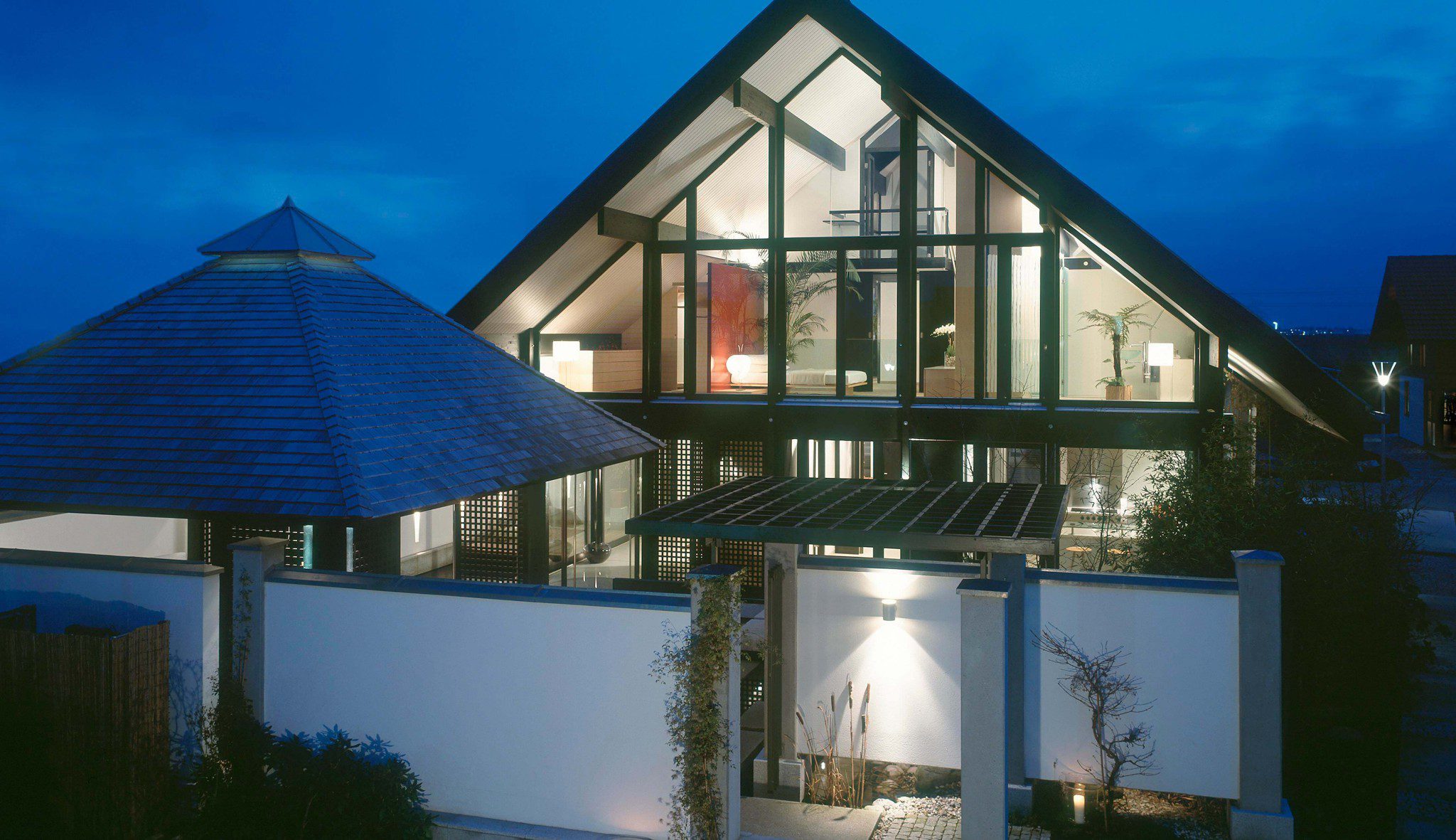 Haus am See: Giebelfassade und Pavillon in der Abenddämmerung