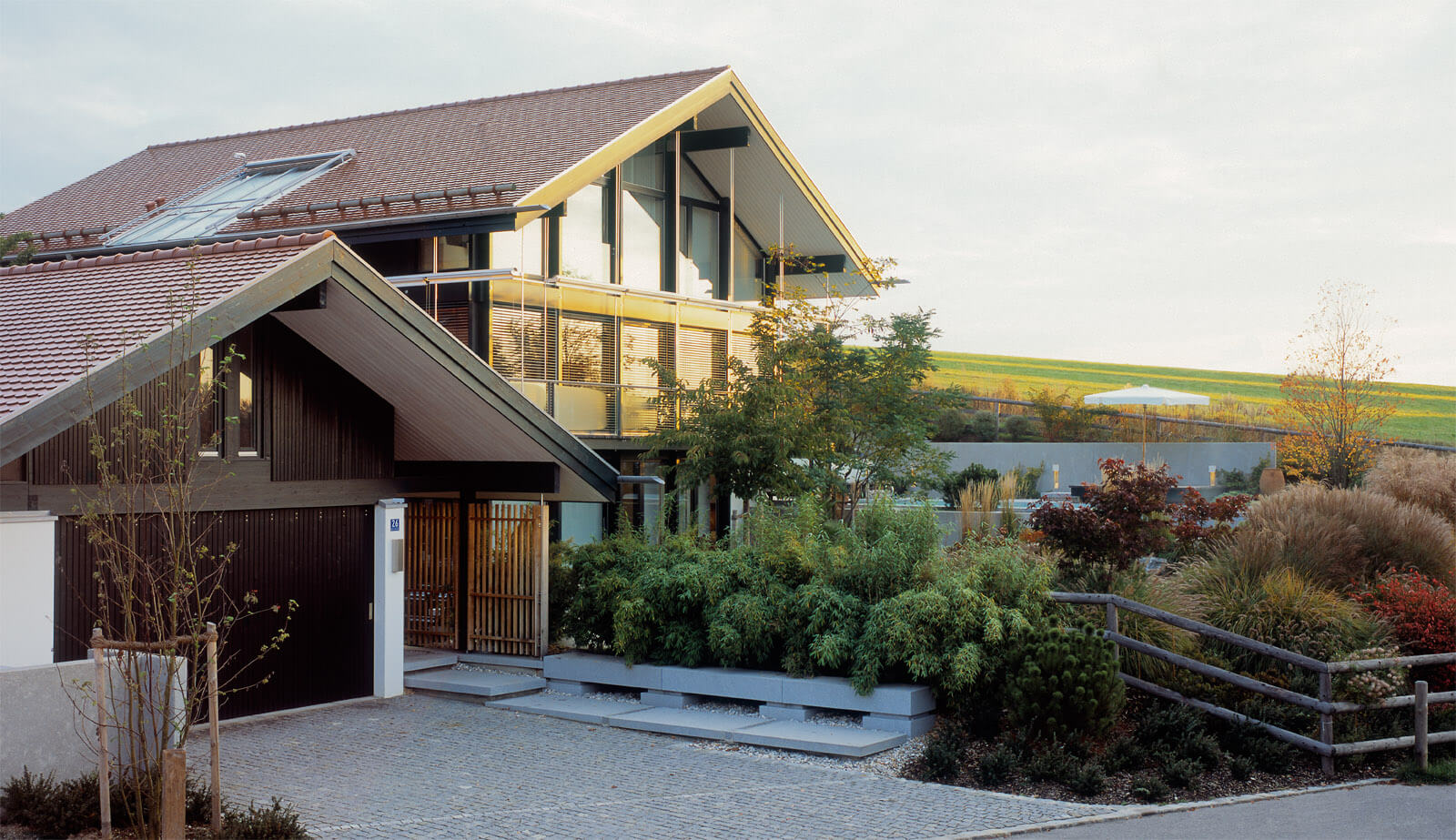 Haus in Hanglage: Satteldachhaus mit Glasgiebel und Vorgarten