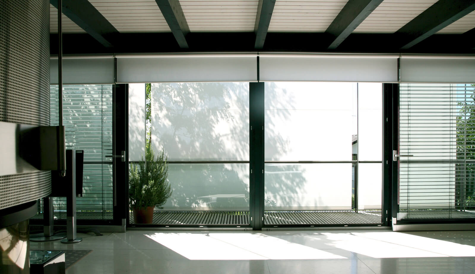 Haus in Hanglage: Wohnraum mit Holzbalkendecke und Glasfront
