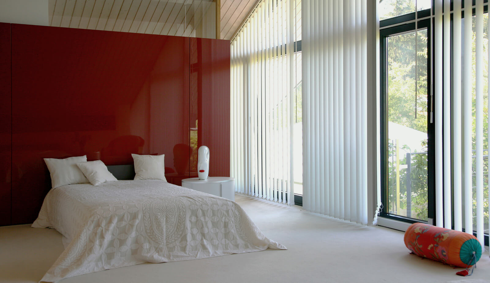 Haus in Hanglage: Schlafzimmer unter der Dachschräge mit roter Wand