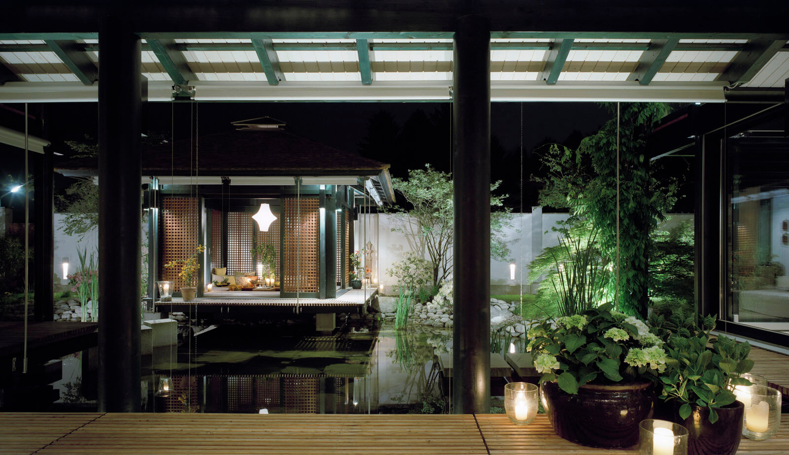 Haus mit Höfen: beleuchteter Gartenpavillon am Koi-Teich bei Nacht