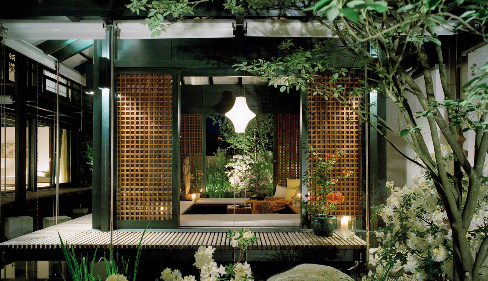 Haus mit Höfen: Gartenpavillon mit Holzgitterwänden und Hängeleuchte