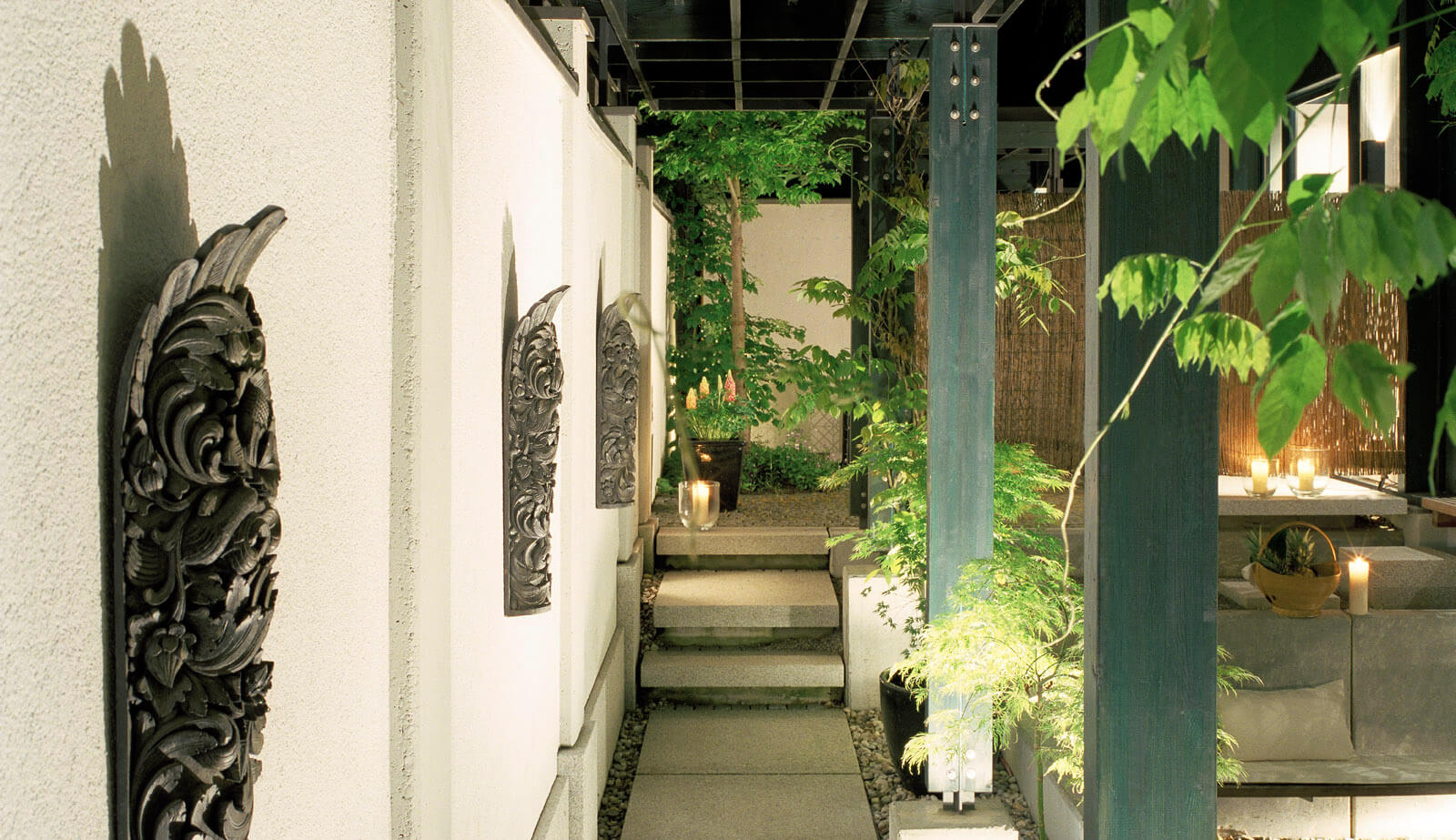 Haus mit Höfen: Hofwand mit geschnitzten Reliefs und Weg unter der Pergola
