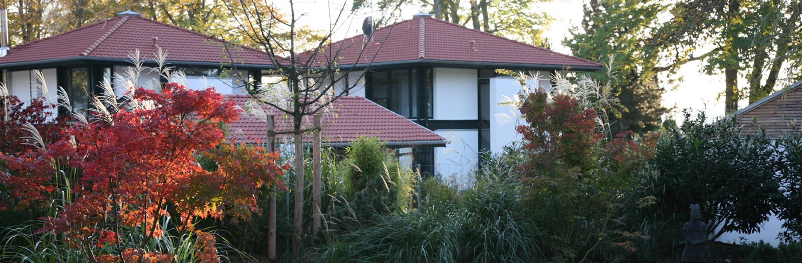 Stadthaus-Pärchen: zwei Zeltdachhäuser hinter herbstlich gefärbtem Garten