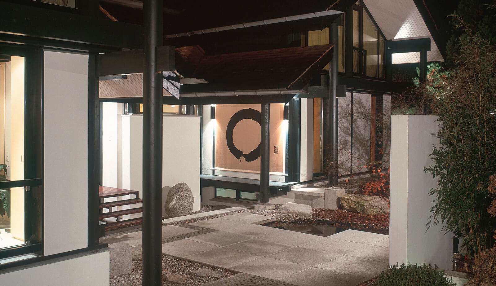 Villa im Park: Eingangshof mit Kalligrafie-Wand und Wasserbecken bei Nacht