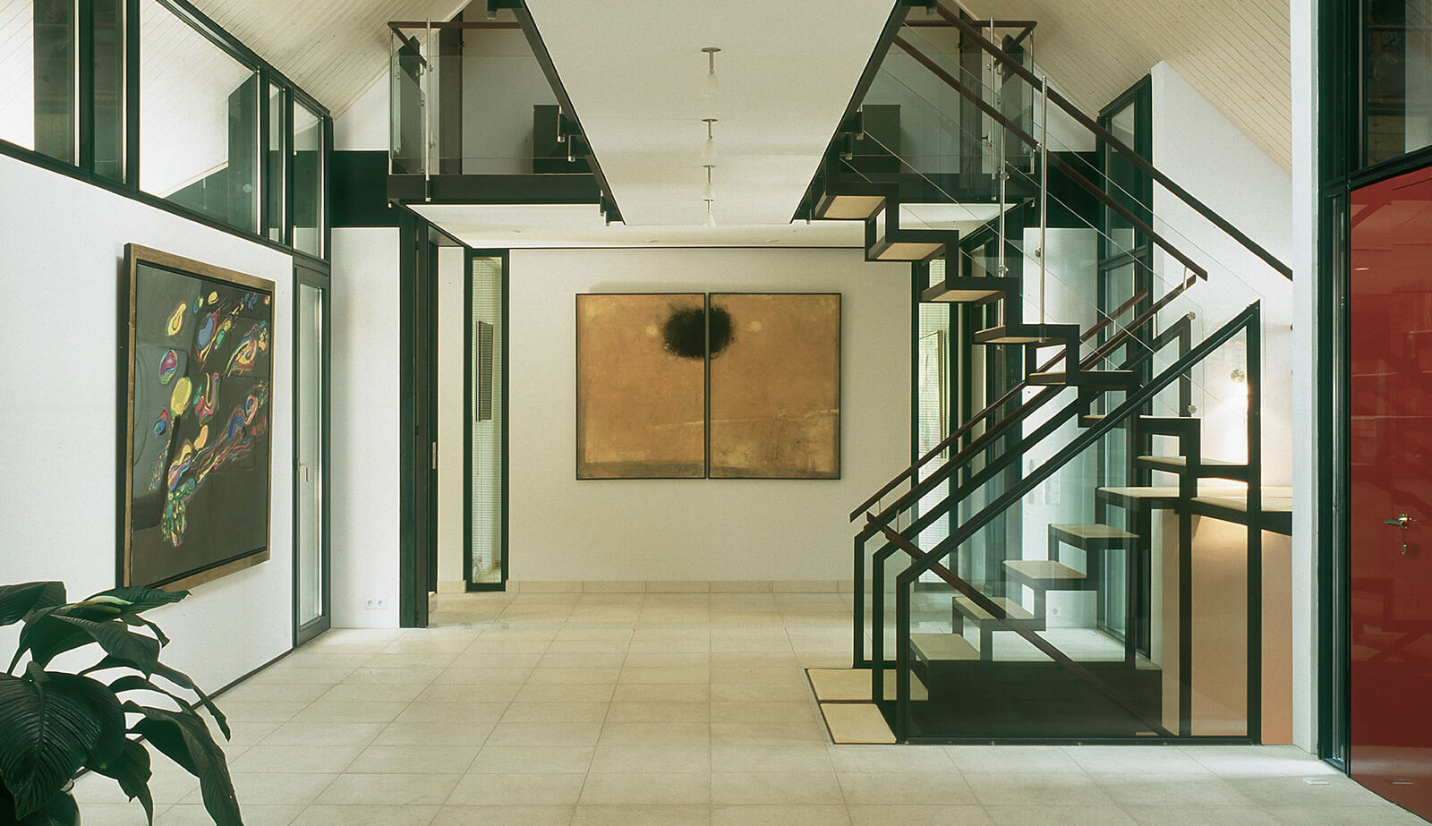 Villa im Park: Halle mit Stahltreppe, Galerien und Kunstwerken