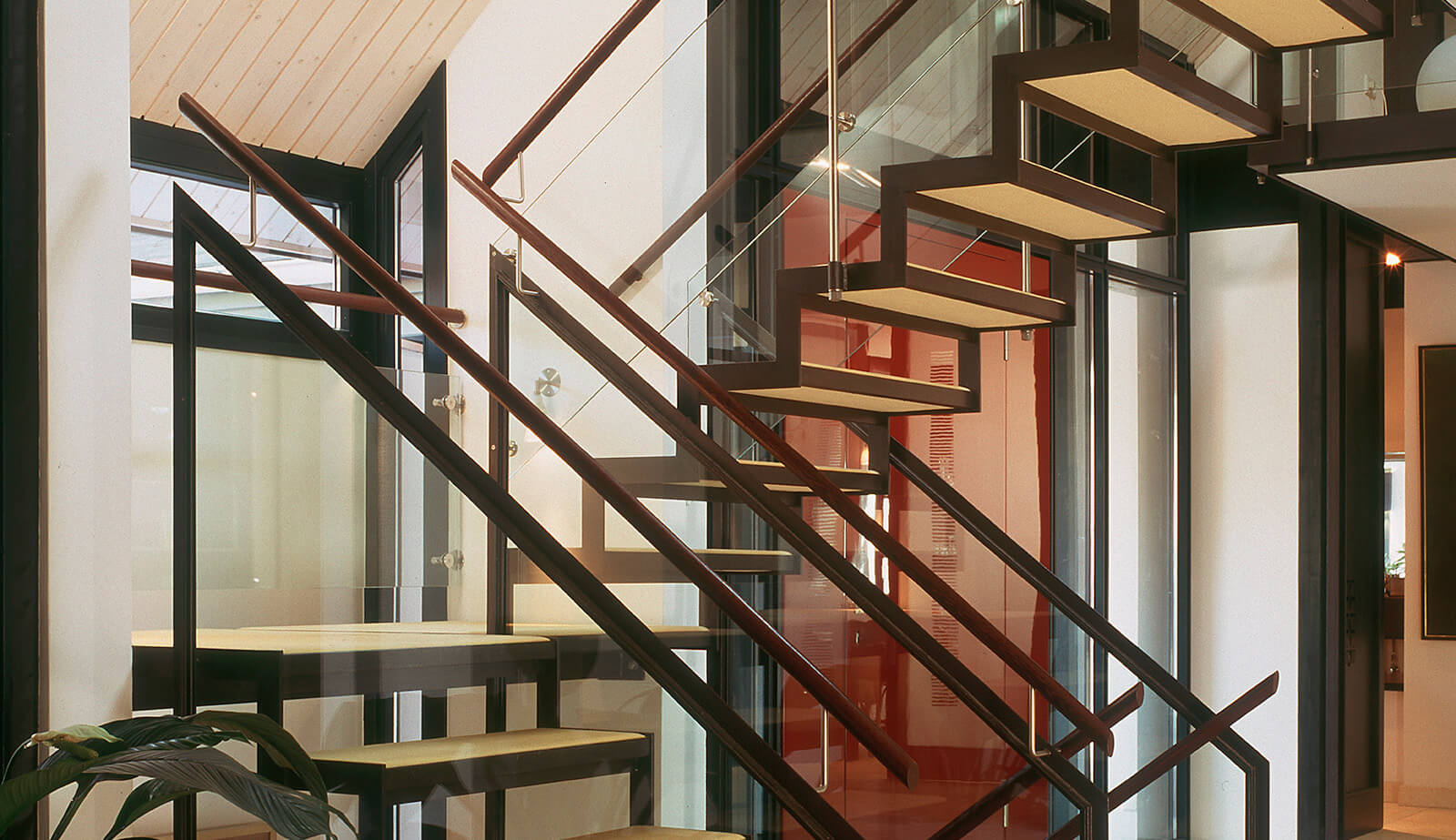 Villa im Park: Stahltreppe mit Holzstufen und Glasgeländer in der Halle