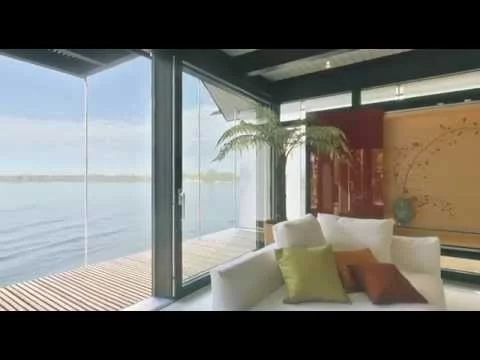 Haus am See: Wohnzimmer mit Polstergruppe und roter Vitrine am See