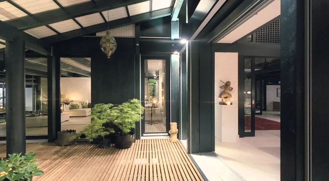 Haus mit Höfen: überdachter Freisitz mit Holzdeck und Blick ins Haus