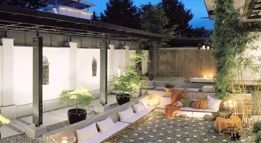 Haus mit Höfen: nördlicher Hof mit Pergola, Sitzbank und gestalteter Grenzwand
